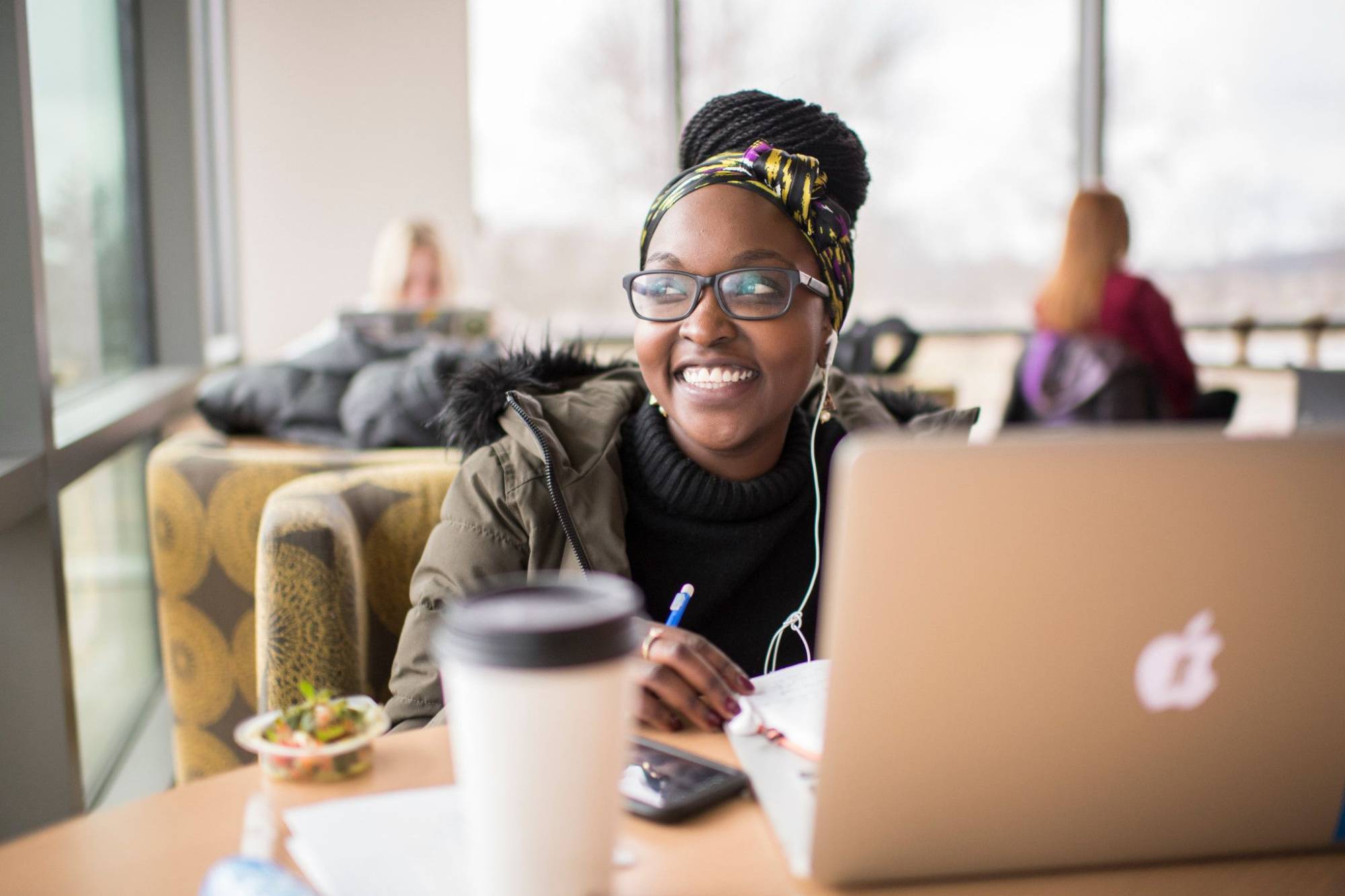 a GVSU adult student on her computer, studying in a coffee shop